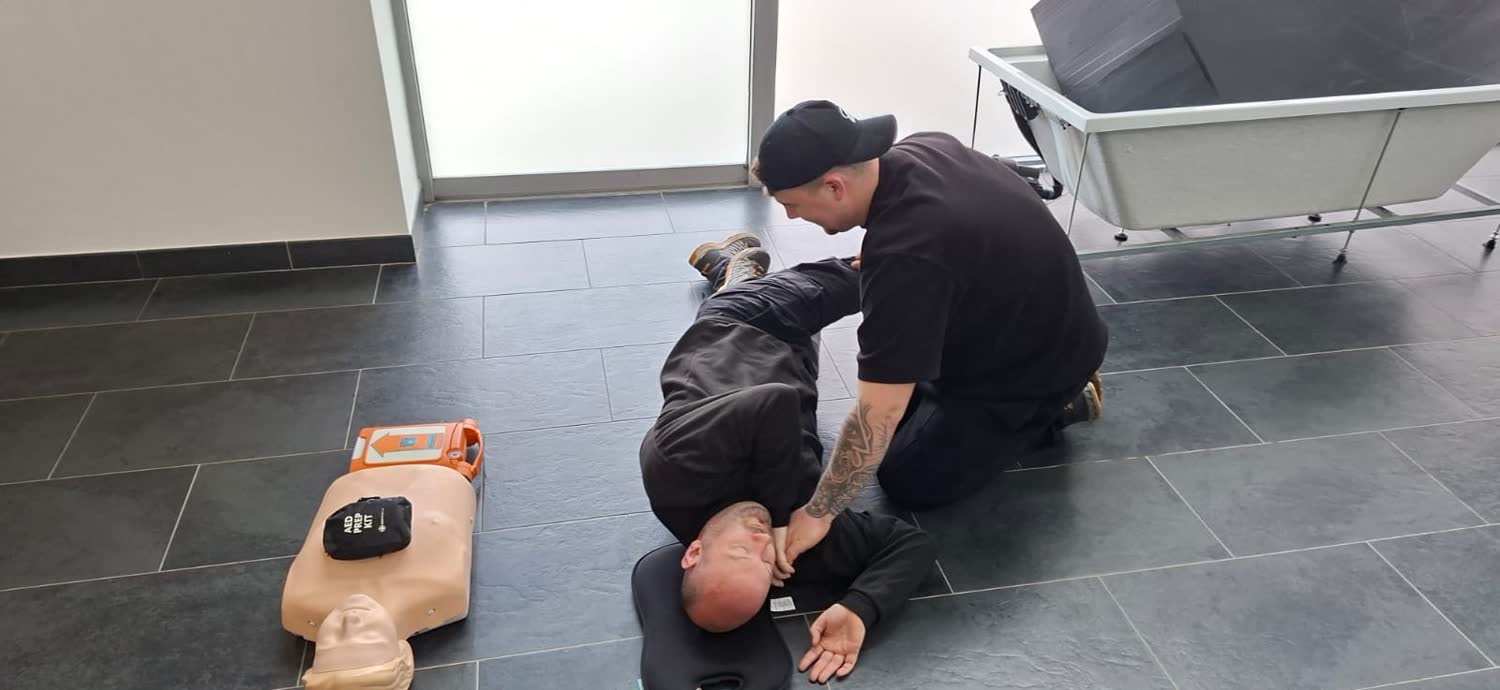 Recovery position practice with an AED prep kit during requalification training