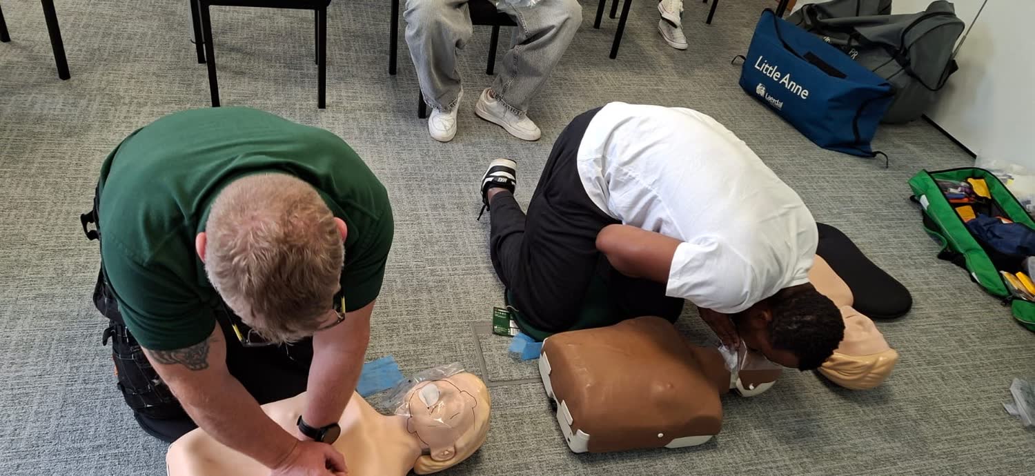 Delegates practising CPR and rescue breaths on a First Aid at Work course