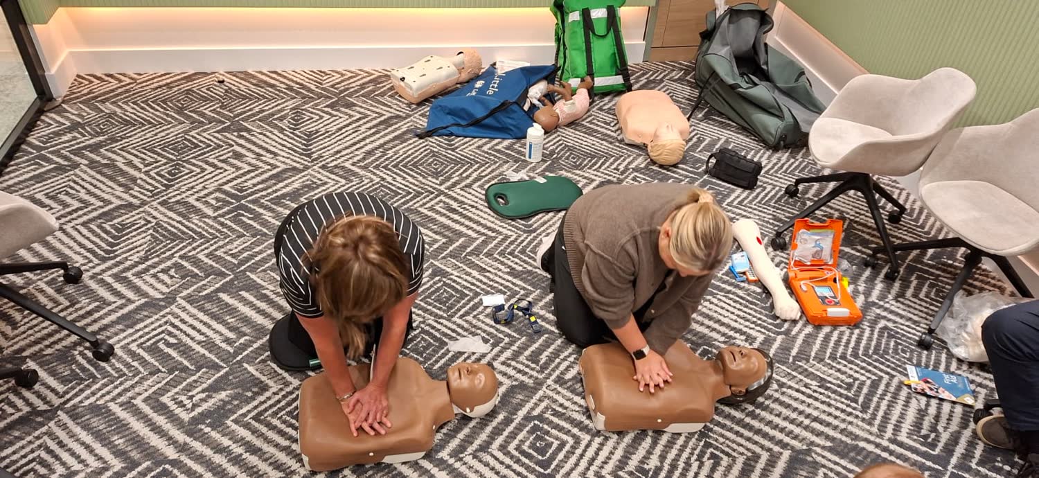 Delegates practising chest compressions on adult manikins during a first aid at work course