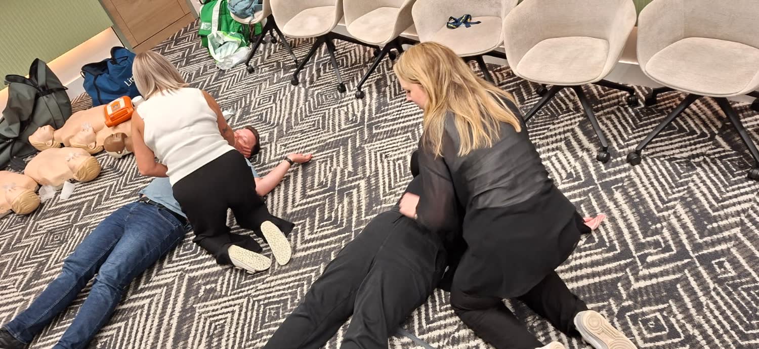 Delegates practising the recovery position on an Emergency First Aid at Work course