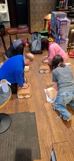 A group of delegates practising chest compressions at a workplace first aid course