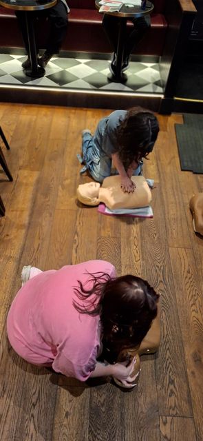 Two delegates practising chest compressions on adult manikins