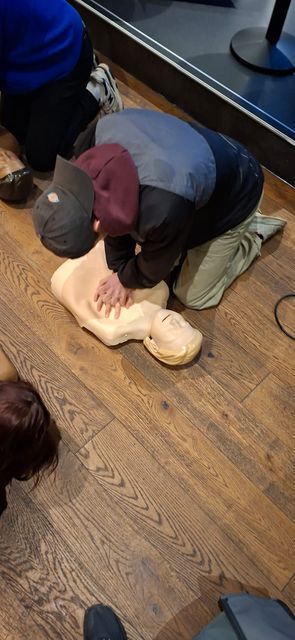 Close up of a delegate's hands positioned on a manikin's chest for compressions