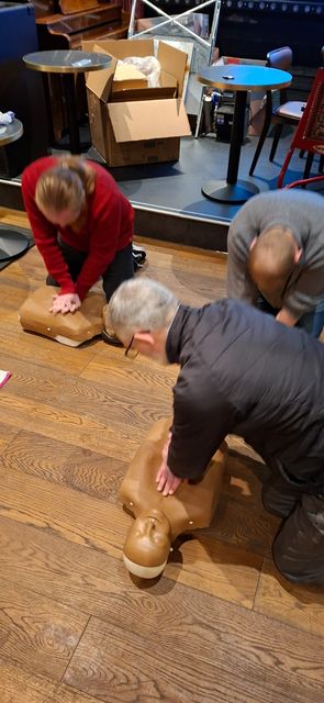 Delegates practising chest compressions side by side on adult manikins