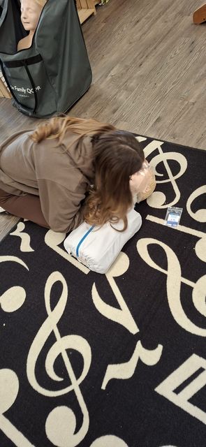 A delegate practising rescue breaths on a child manikin during paediatric training