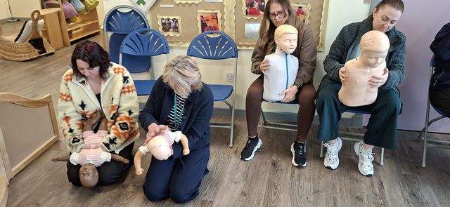 Nursery staff practising infant and child first aid together