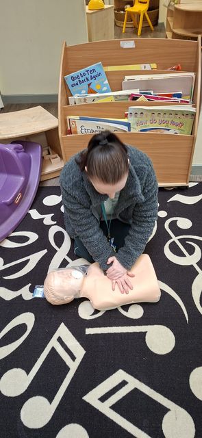 A delegate practising chest compressions on a child manikin