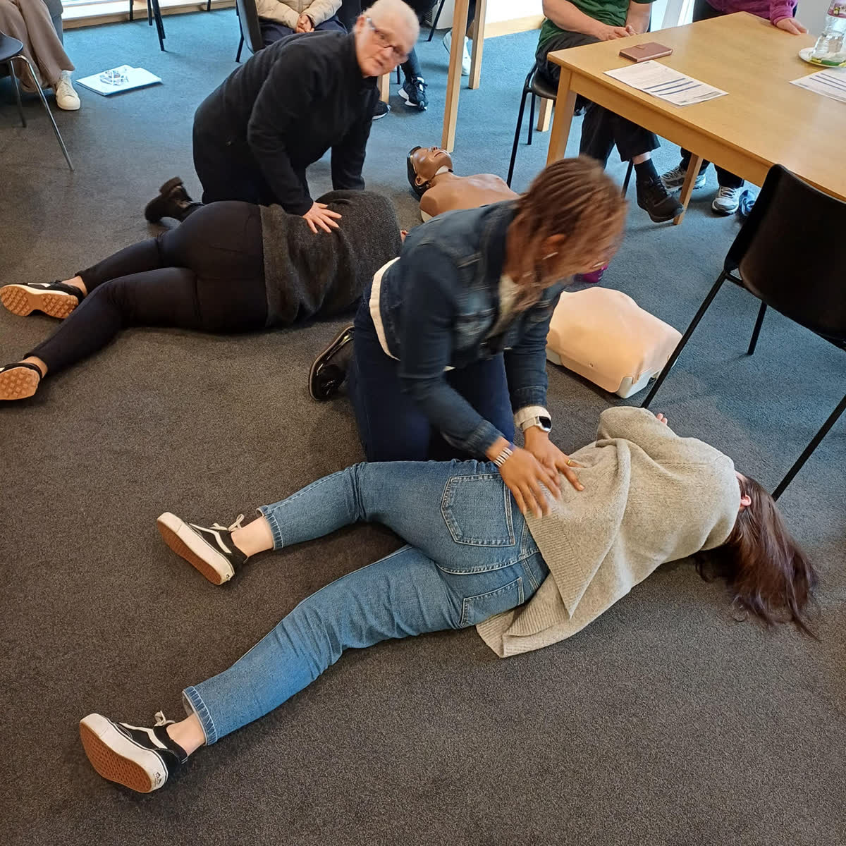 Delegates practising the recovery position during a first aid course
